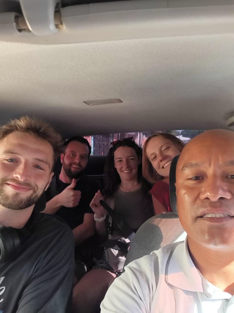 Happy passengers with the driver inside the car