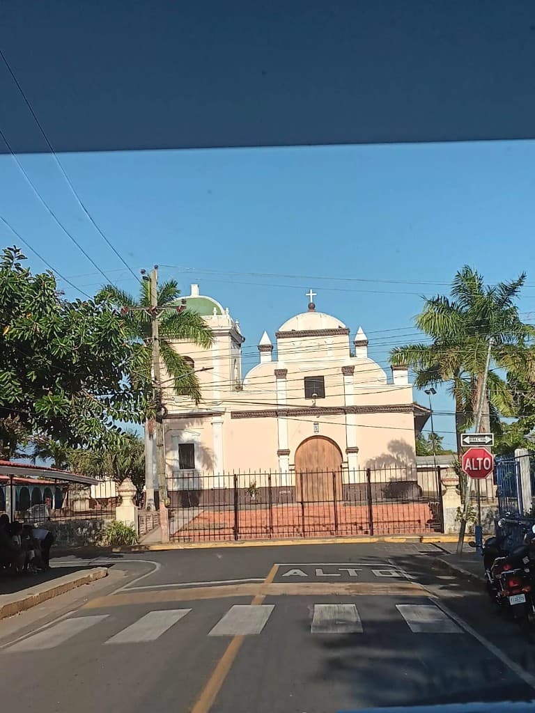 Colorful church and palm trees at a street corner