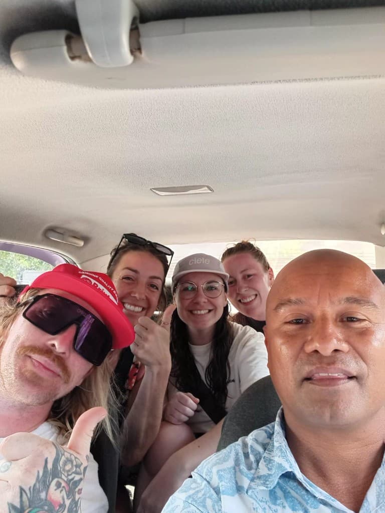Travelers and driver smiling together on a tour